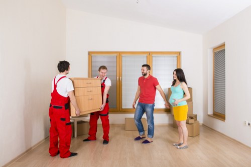 Movers handling boxes and furniture in a Fitzrovia flat building
